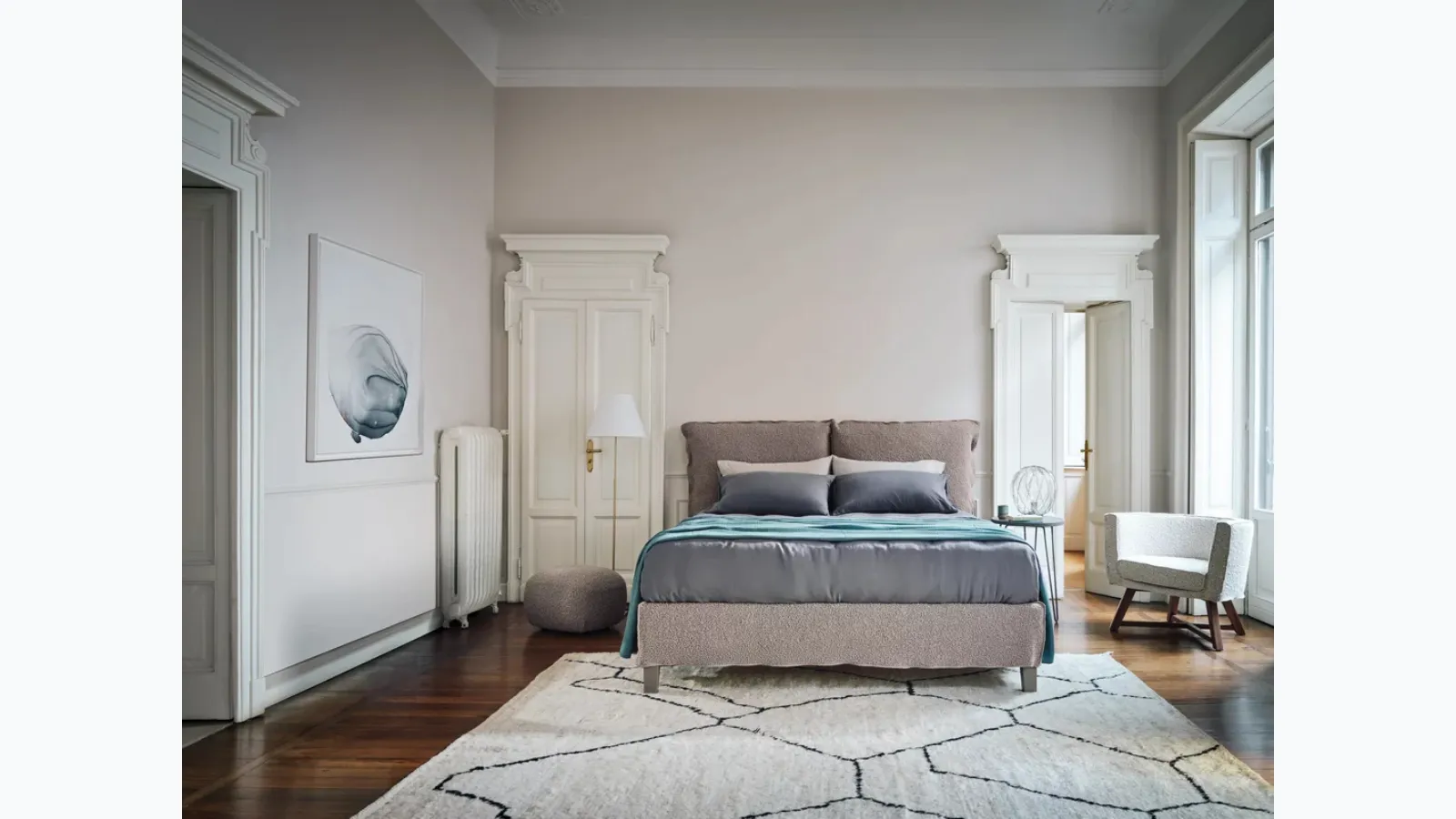 Gray padded armchair by Gervasoni.