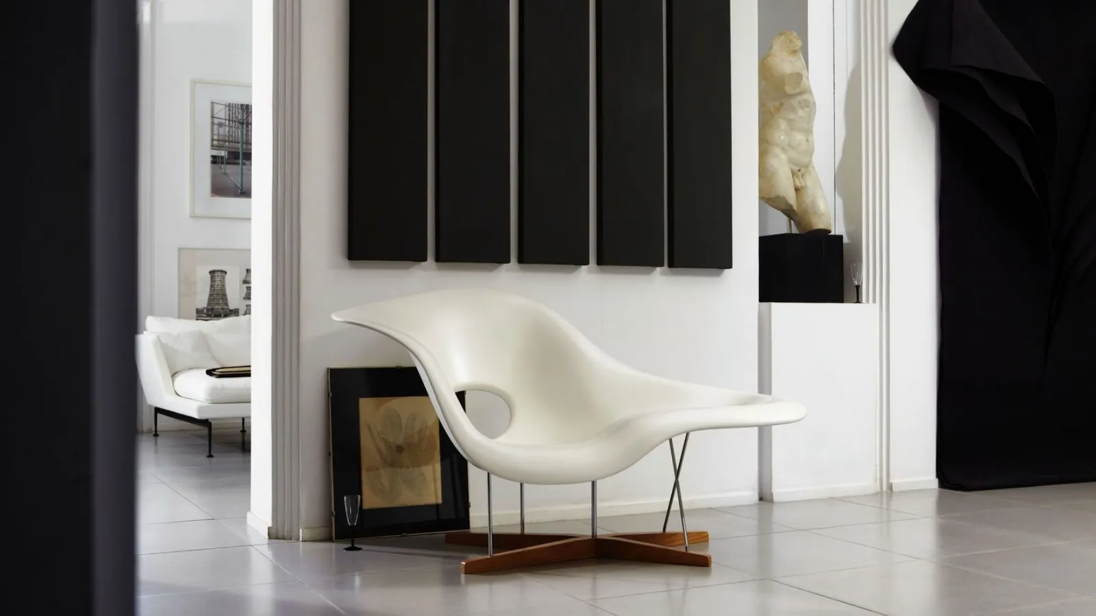 Designer armchair with a white lacquered polyester resin shell and a base made of tubular steel and oak wood. La Chaise by Vitra.