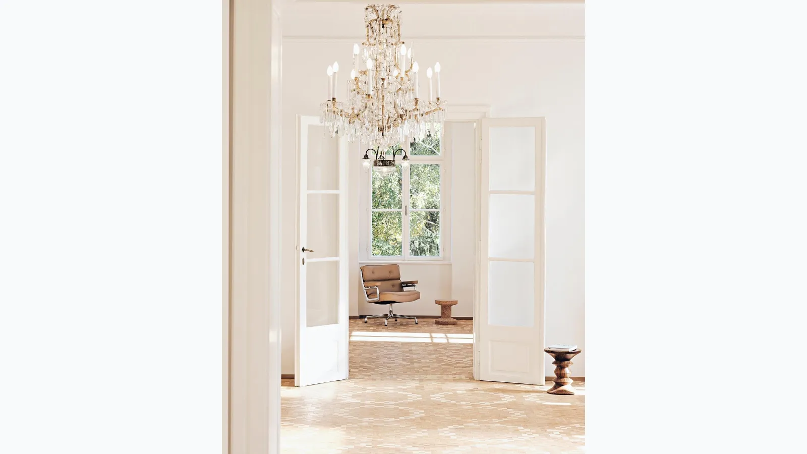 Padded leather armchair with a four-spoke base in chrome-plated die-cast aluminum Lobby Chair ES 105 by Vitra.