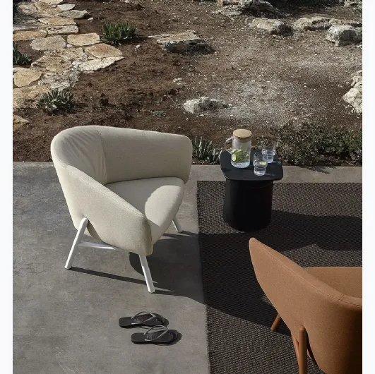 Fabric armchair with a curved and welcoming seat, with a light metal frame painted in Tuile by Kristalia.