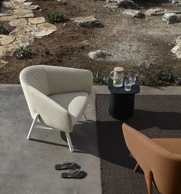 Fabric armchair with a curved and welcoming seat, with a light metal frame painted in Tuile by Kristalia.