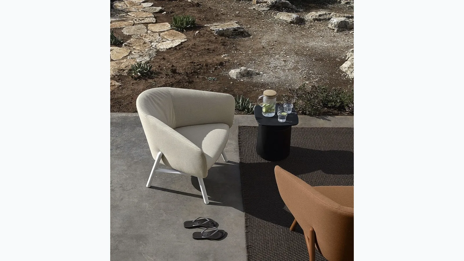 Fabric armchair with a curved and welcoming seat, with a light metal frame painted in Tuile by Kristalia.