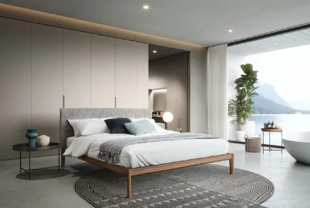 Walnut Neos bed with headboard upholstered in Novamobili fabric.