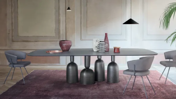 Cop Table with ceramic top and metal base formed by stylized elements inspired by bottles, precious goblets, and champagne cups by Bonaldo.