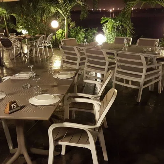 Outdoor table with a central leg with 4 spokes and top in polypropylene, engraved with a round perforated pattern. Nardi Clip.