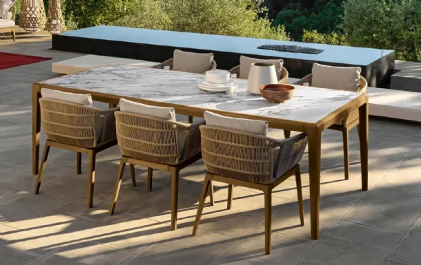 Table in stoneware and wood and chairs in wood and Cruise Teak fabric by Talenti.