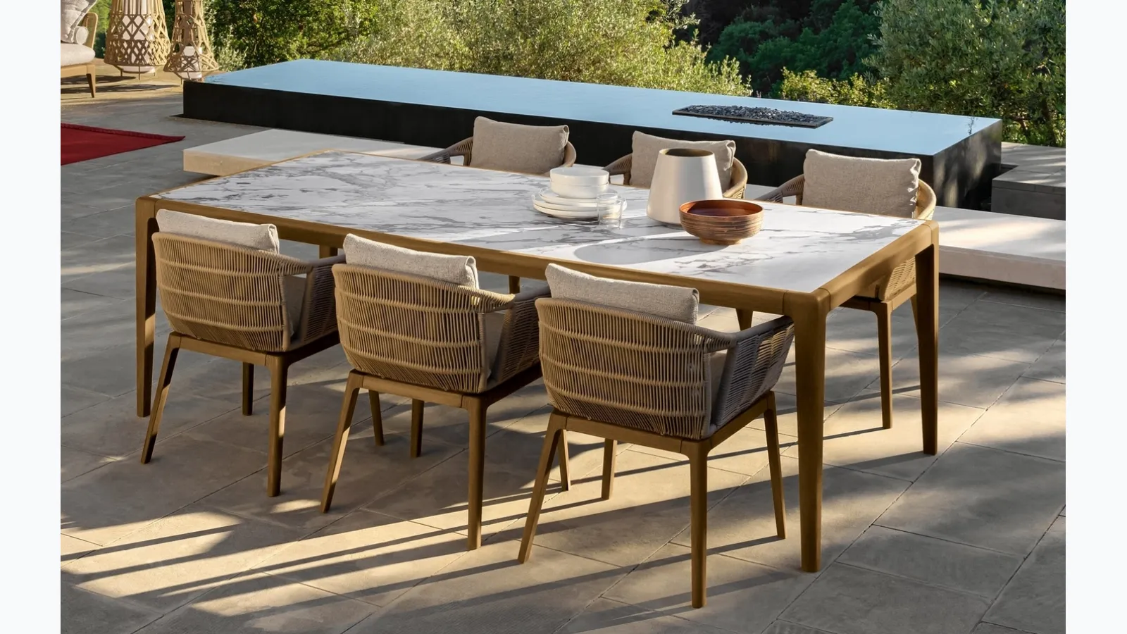 Table in stoneware and wood and chairs in wood and Cruise Teak fabric by Talenti.