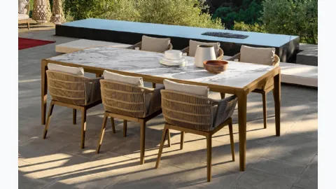 Table in stoneware and wood and chairs in wood and Cruise Teak fabric by Talenti.