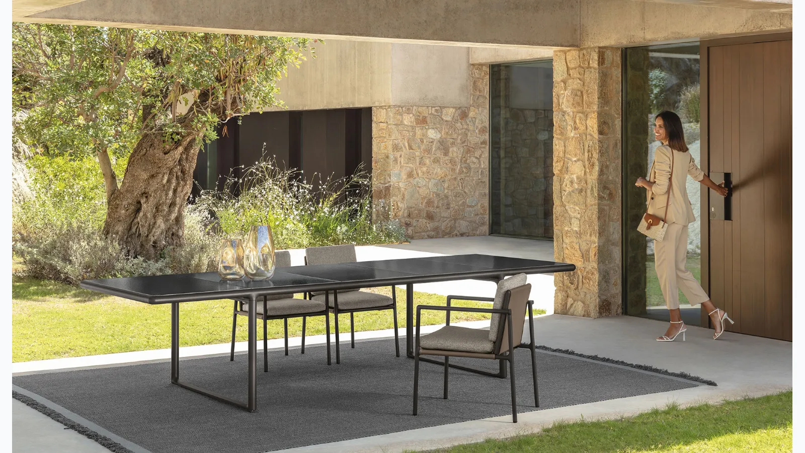 Extendable Tressé table in glazed lava stone with eco-leather chairs with cushions in Talenti fabric.