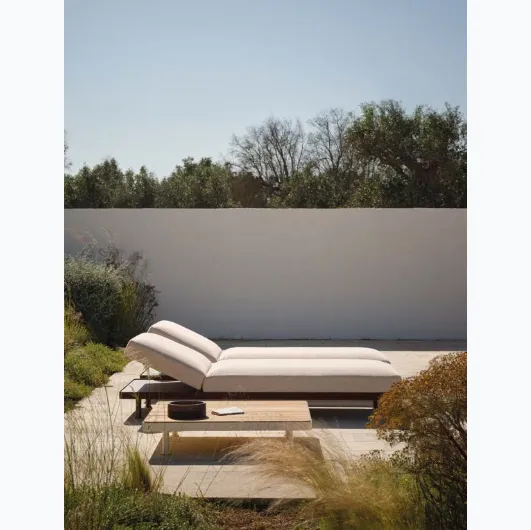 Padded sunbed and wooden table by Fast.
