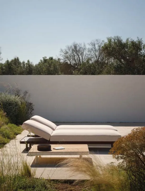 Padded sunbed and wooden table by Fast.