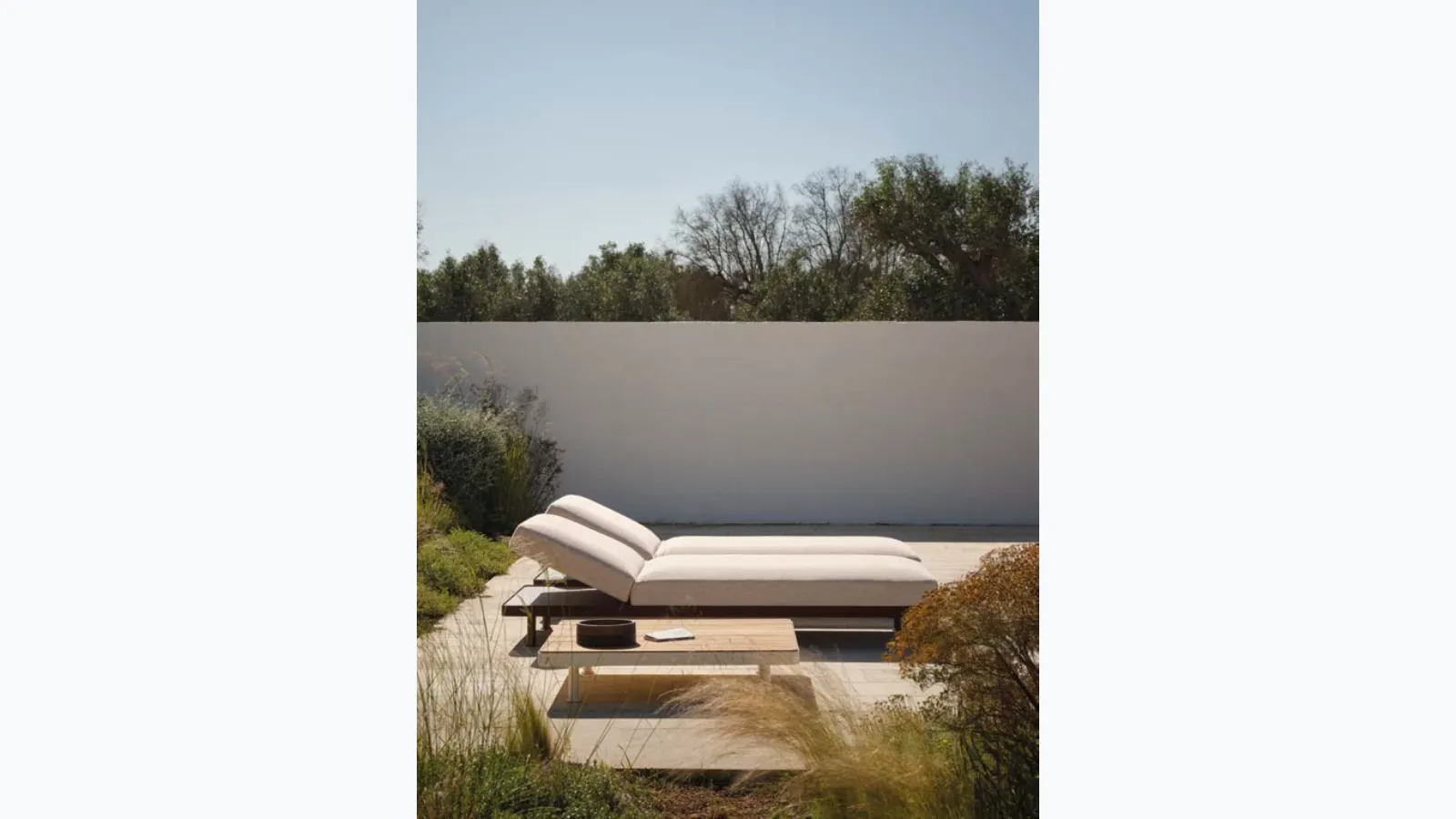 Padded sunbed and wooden table by Fast.