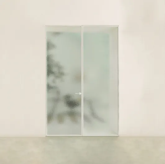 The Aladin Double Swing Plain Duo interior door in glass with an aluminum frame by Glas Italia.